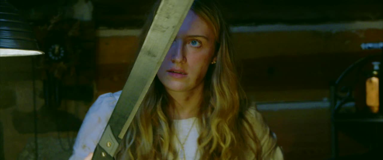 A girl grips a blade in a dark cabin